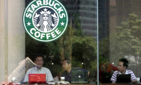 People work on their laptops at a Starbucks: Some New York locations are considering cutting off the power source so customers are forced to shut down.