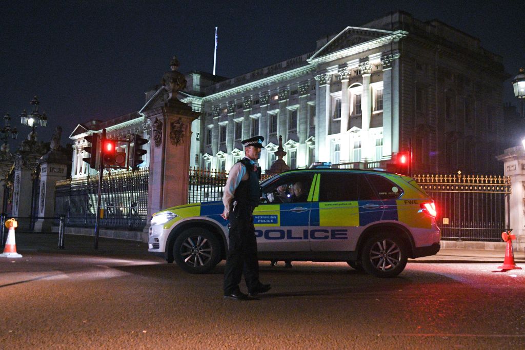 Police teams secure the roads behind a cordoned area following an apparent attack on two police officers at Buckingham Palace on August 25, 2017 in London