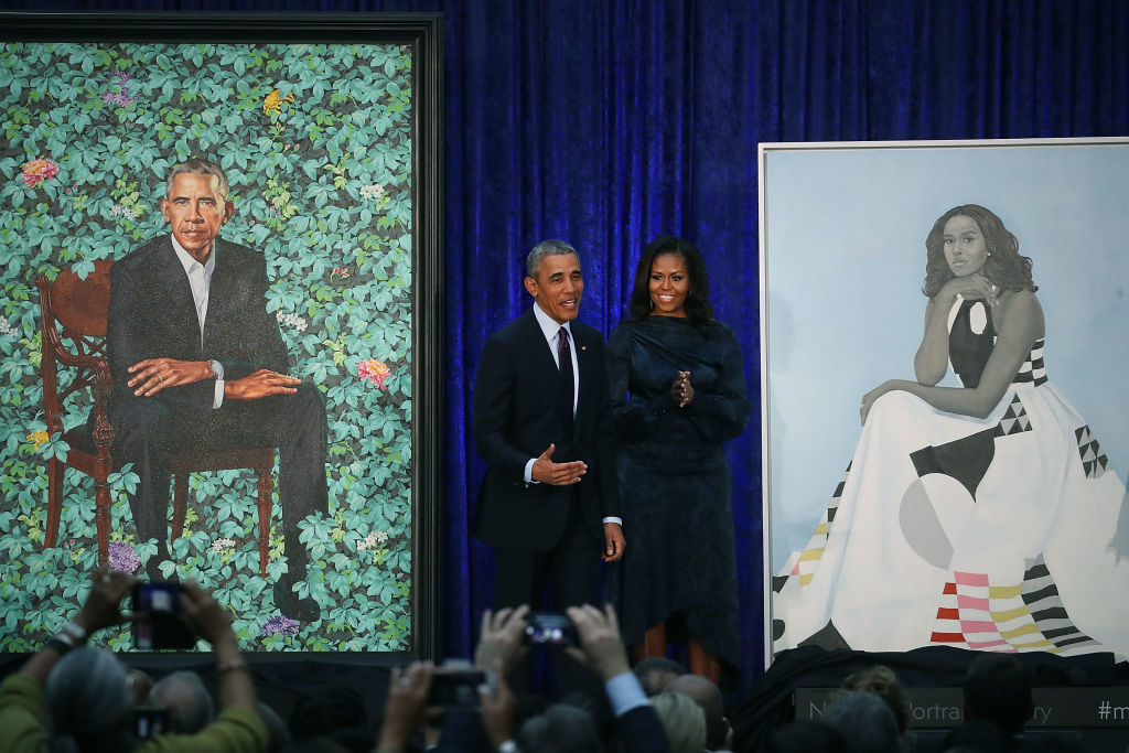 Barack and Michelle Obama with their official portraits.