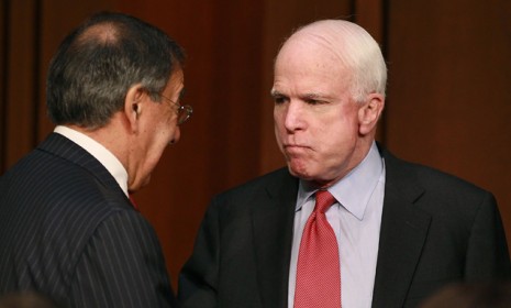 A disgruntled-looking John McCain talks with Defense Secretary Leon Panetta during a Senate Armed Services Committee hearing on November 15, 2011.