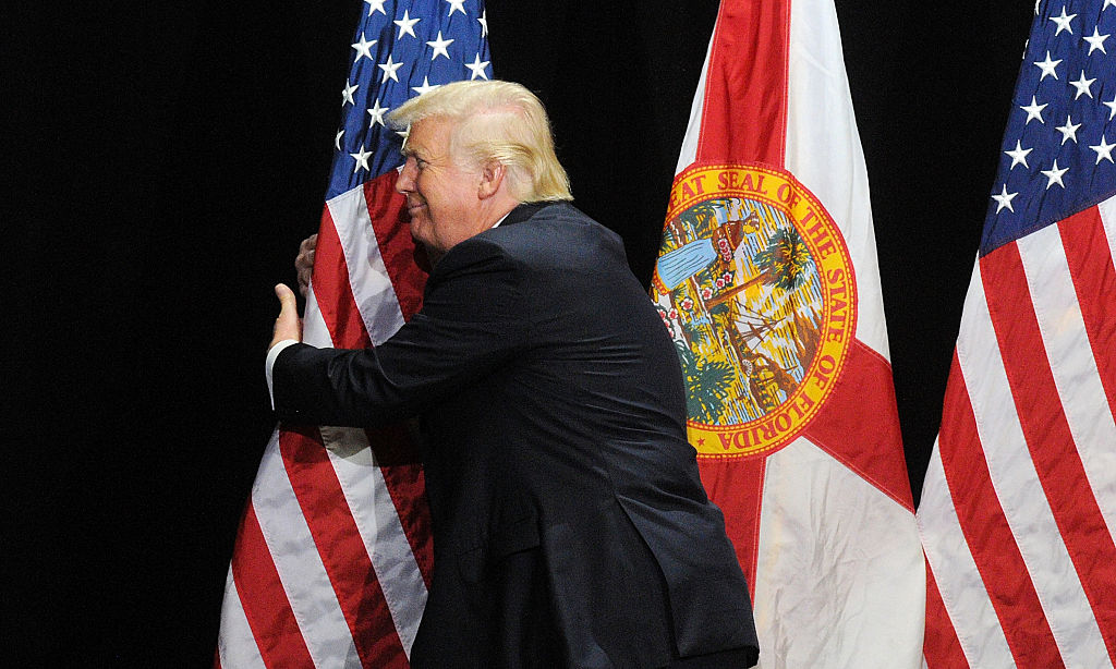Donald Trump hugs a flag.