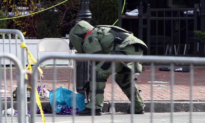 A member of the bomb squad investigates a suspicious item on the road near Kenmare Square on April 15.