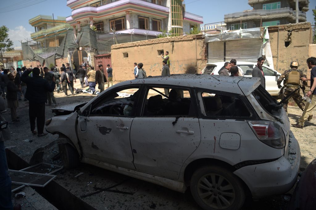 Afghan residents inspect the site of a suicide bombing outside a voter registration centre in Kabul on April 22, 2018. 