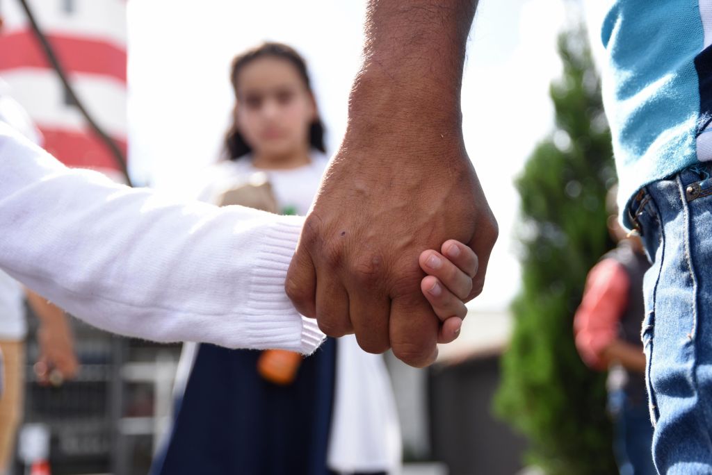 A father holds his daughter&#039;s hand.
