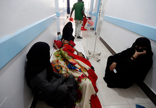 Women wait in a hospital hallway with children suspected to be infected with cholera.