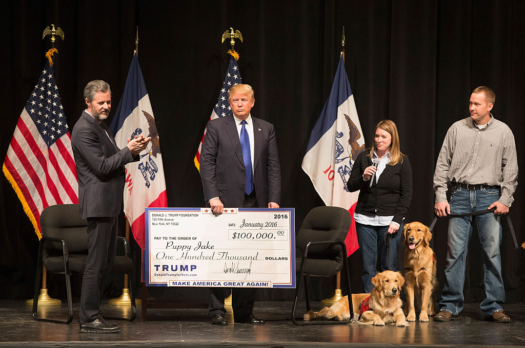 Donald Trump hands out a check at a campaign rally