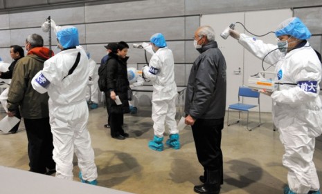 Japanese medics check evacuees for radiation.