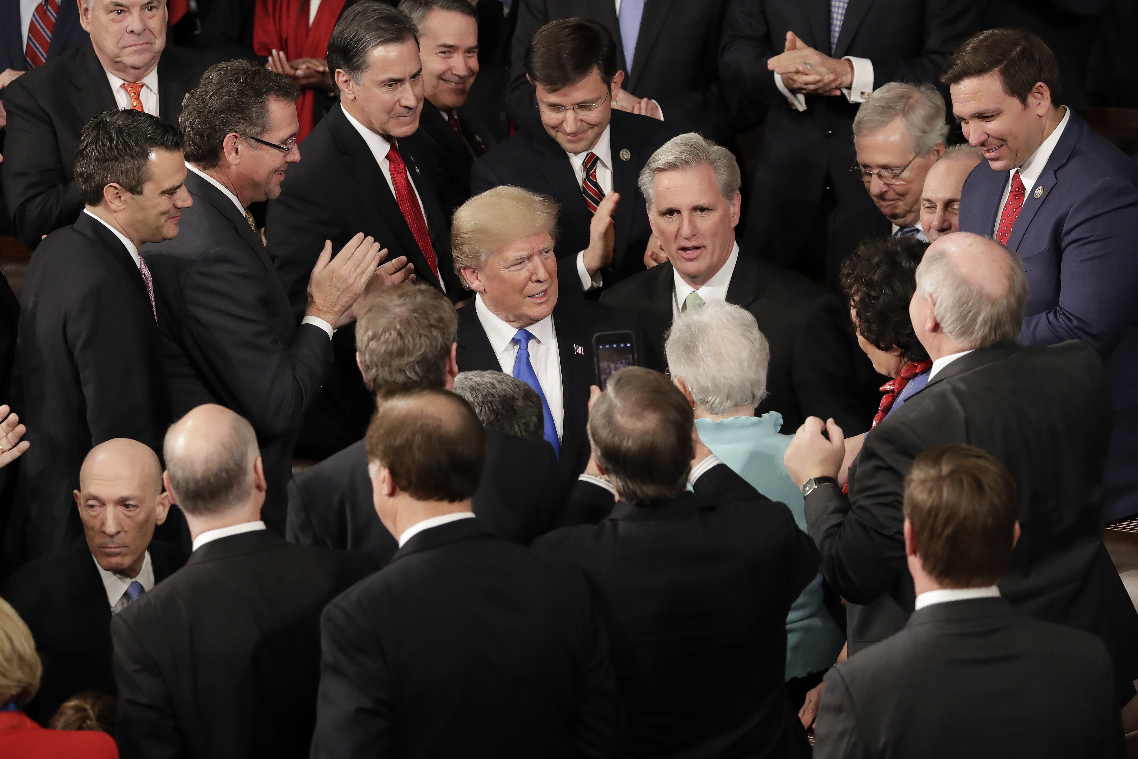 President Donald Trump surrounded by members of Congress. 