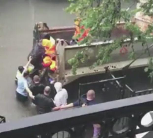 Houston residents help carry a pregnant woman to safety.