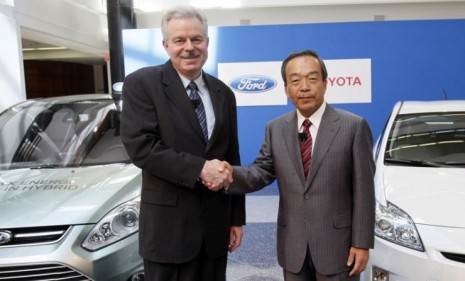 Top executives from Ford and Toyota shake hands during a news conference Monday, after announcing the car makers&#039; collaboration on SUV hybrids.