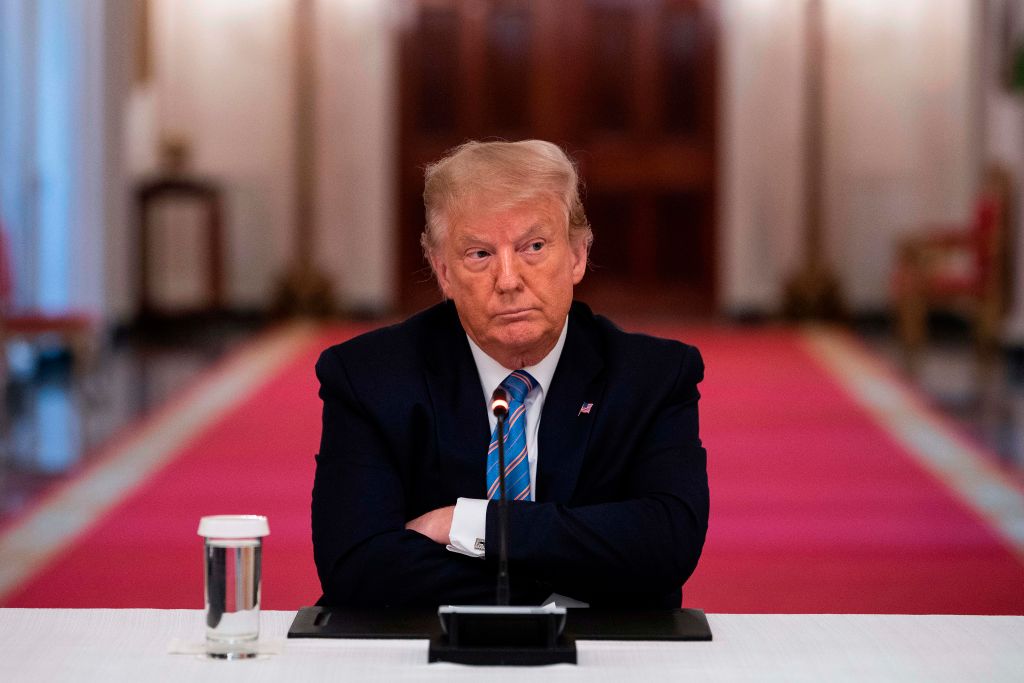 Donald Trump sitting with his arms crossed against his chest.