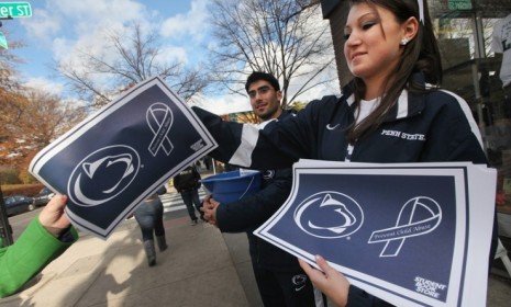Penn State cheerleaders pass out anti-child abuse placards