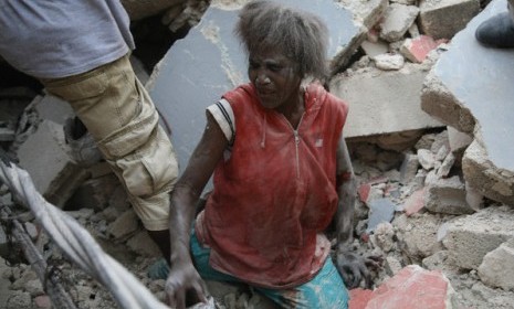 A woman emerges from the rubble caused by the catastrophic earthquake that struck Haiti on January 12, 2010.