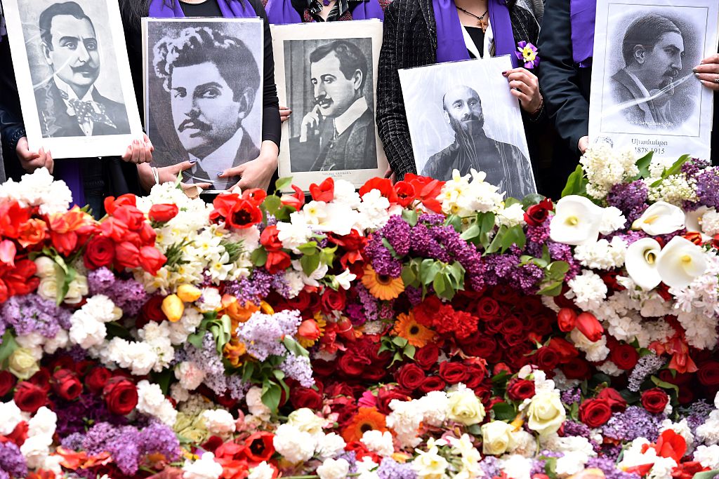 People hold photos of victims of the Armenian Genocide.