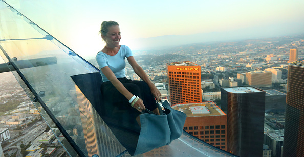 A woman goes down the SkySlide high above downtown Los Angeles.