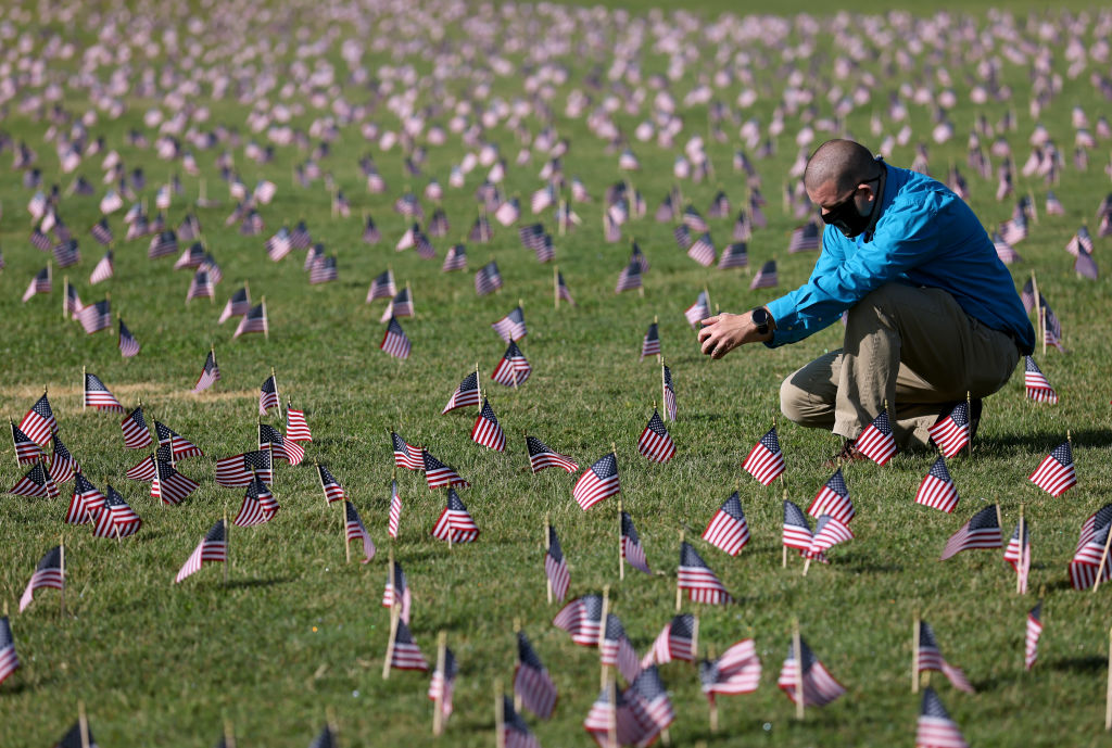 A man prays at a memorial for American COVID-19 victims.