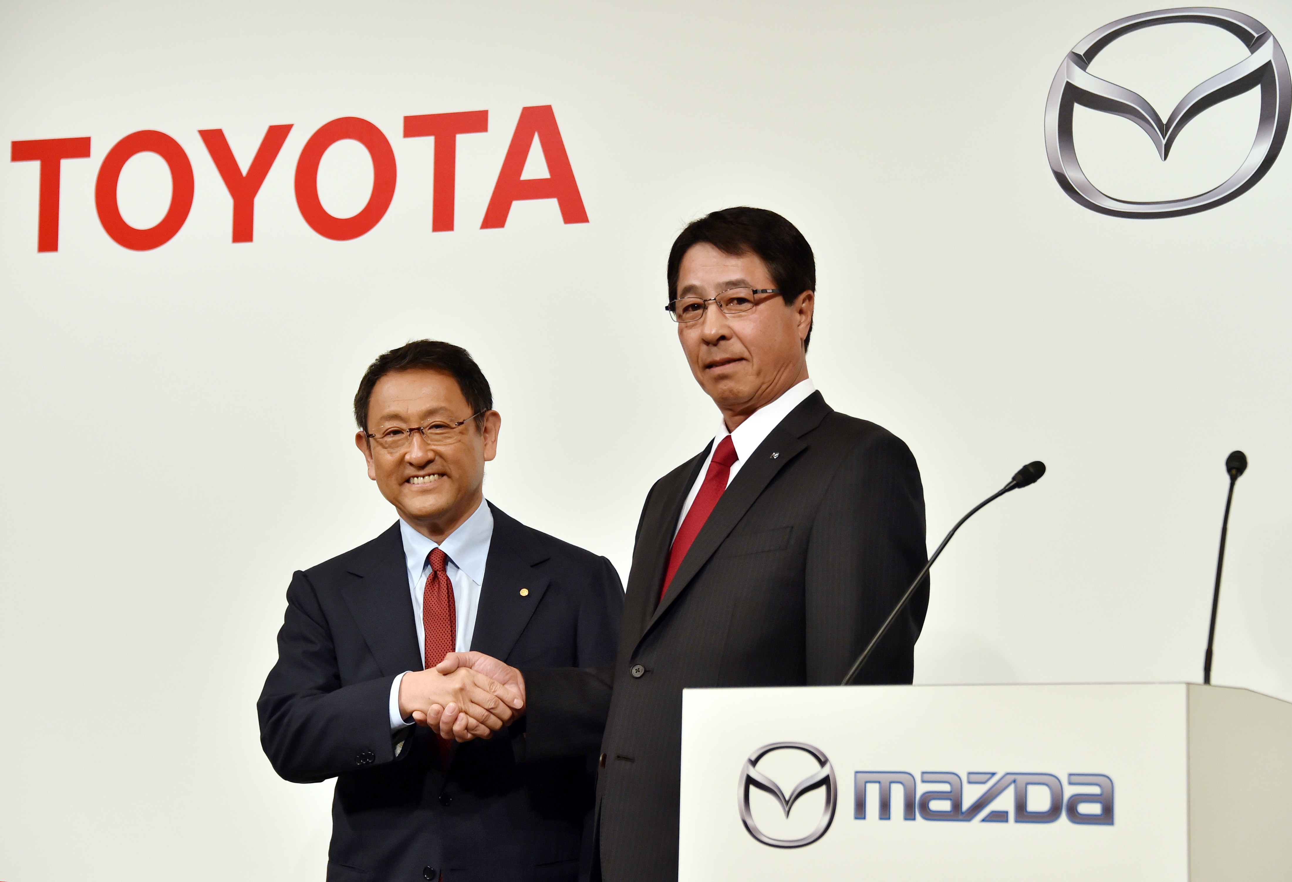 Toyota president and Mazda president shake hands