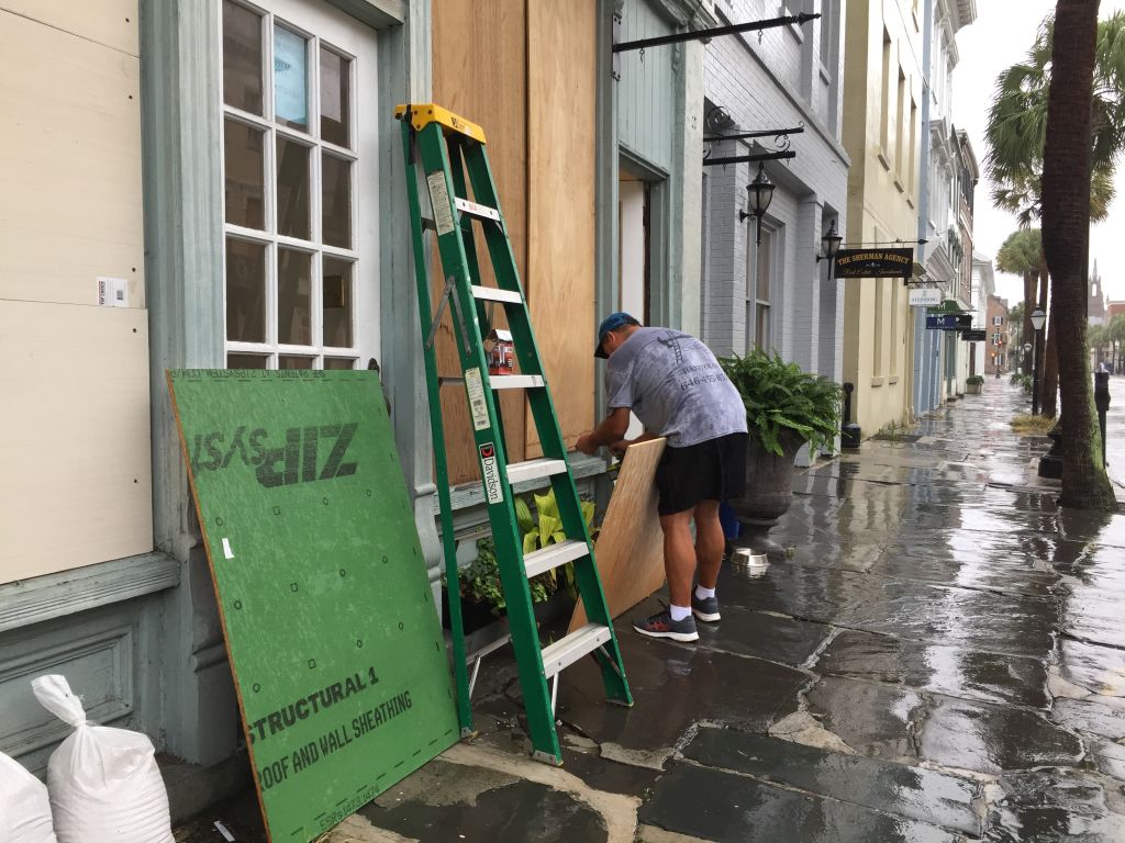A man boards up his jewelry store in Charleston.