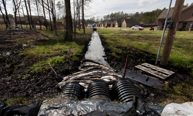 Spilled oil is seen in a drainage ditch near evacuated homes in Mayflower, Arkansas March 31, 2013.