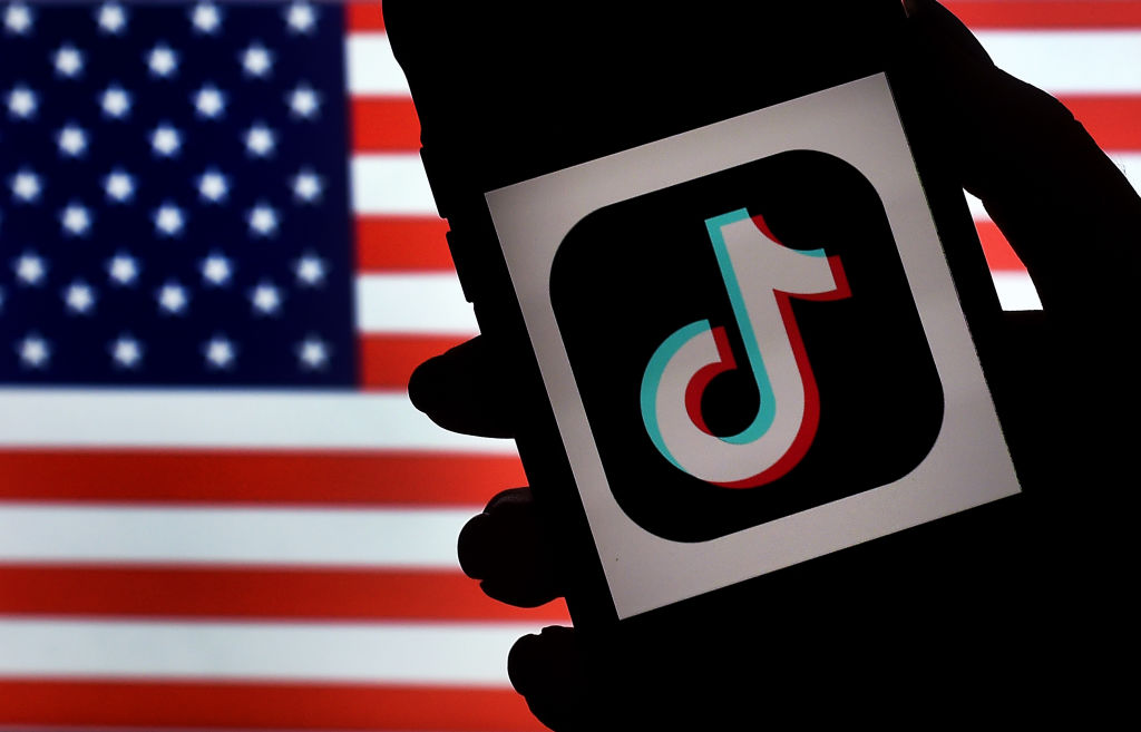 In this photo illustration, the social media application logo, TikTok is displayed on the screen of an iPhone on an American flag background on August 3, 2020 in Arlington, Virginia. 