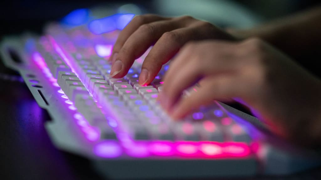 A person types on a computer keyboard.