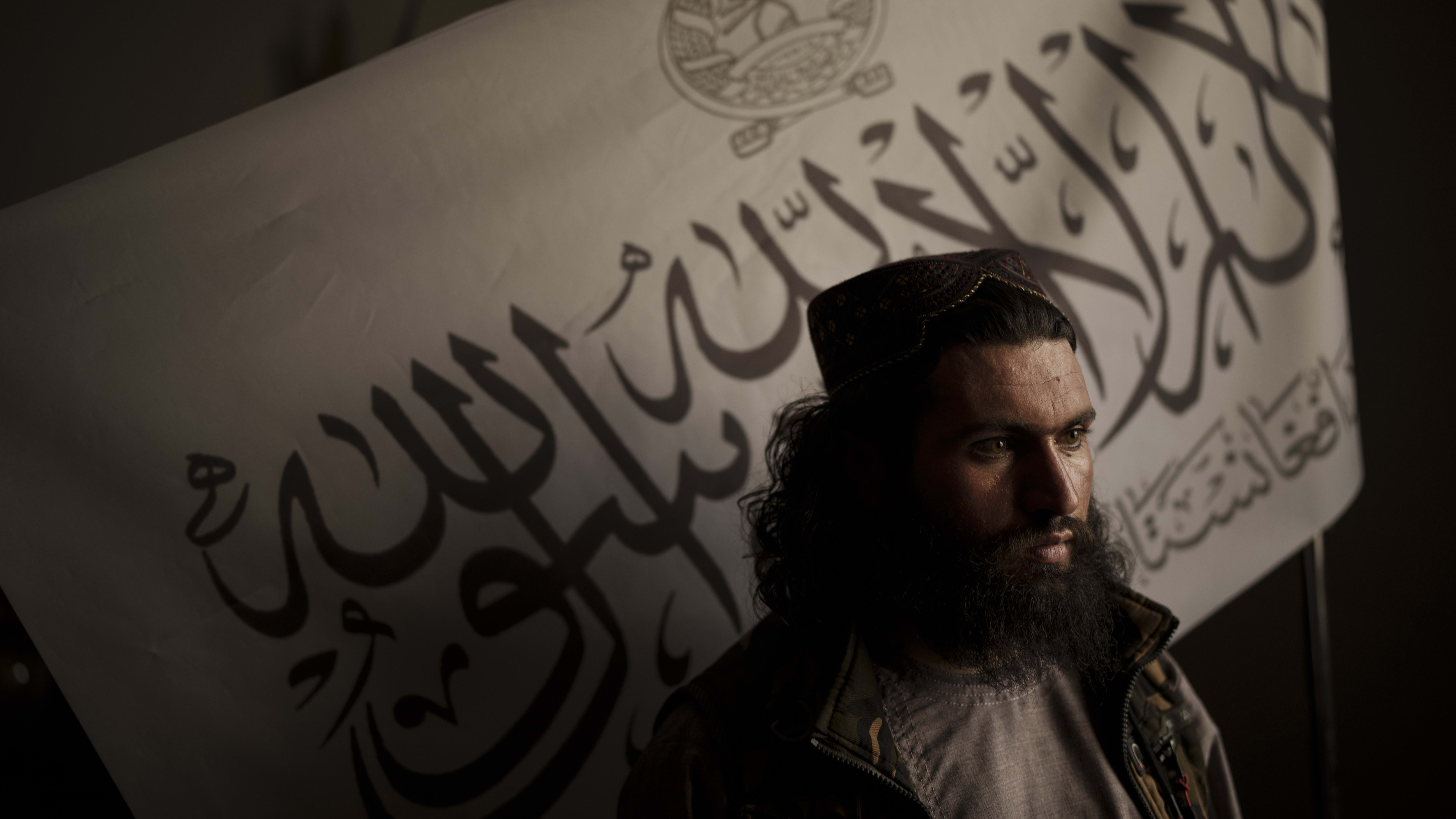 A Taliban official in front of a flag.