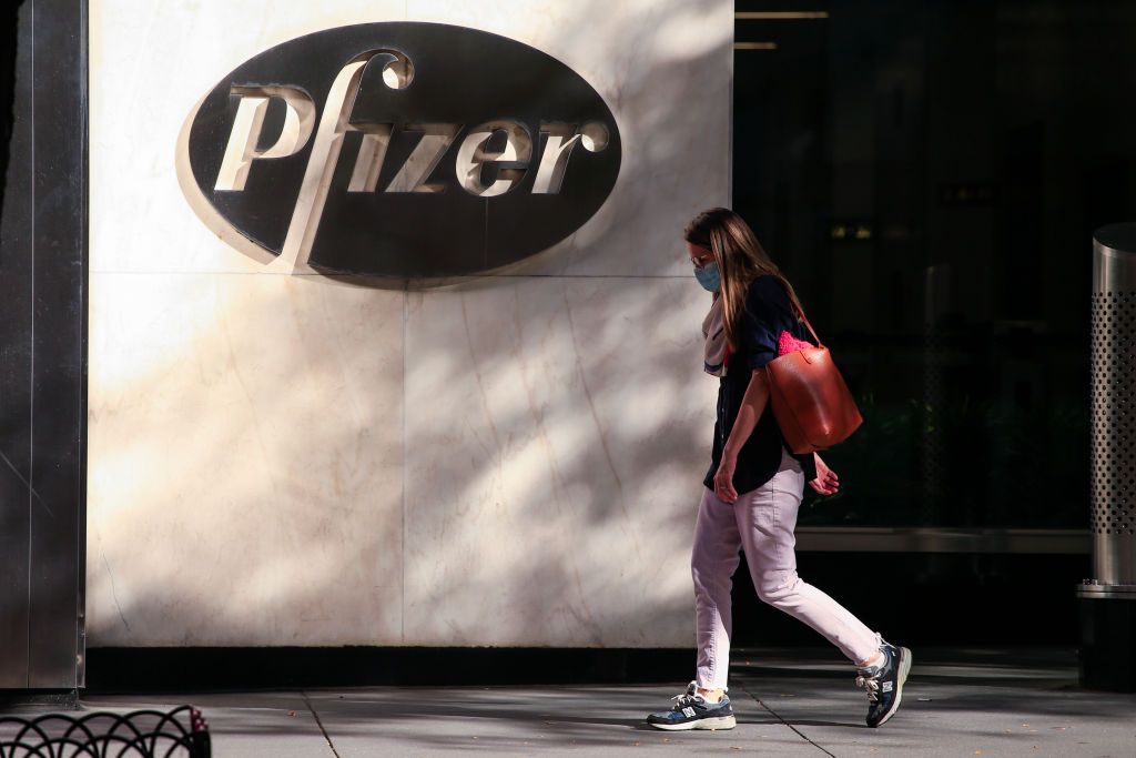 Woman walking past Pfizer building.