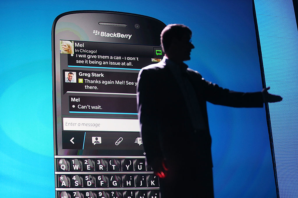 BlackBerry CEO in front of BlackBerry phone.