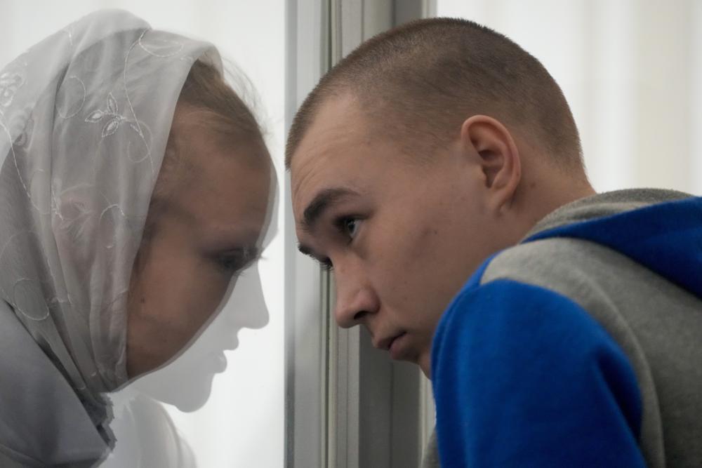 Russian Sgt. Vadim Shishimarin listens to his translator during a court hearing in Kyiv, Ukraine, Monday, May 23, 2022. The court sentenced the 21-year-old soldier to life in prison on Monday for killing a Ukrainian civilian, in the first war crimes trial