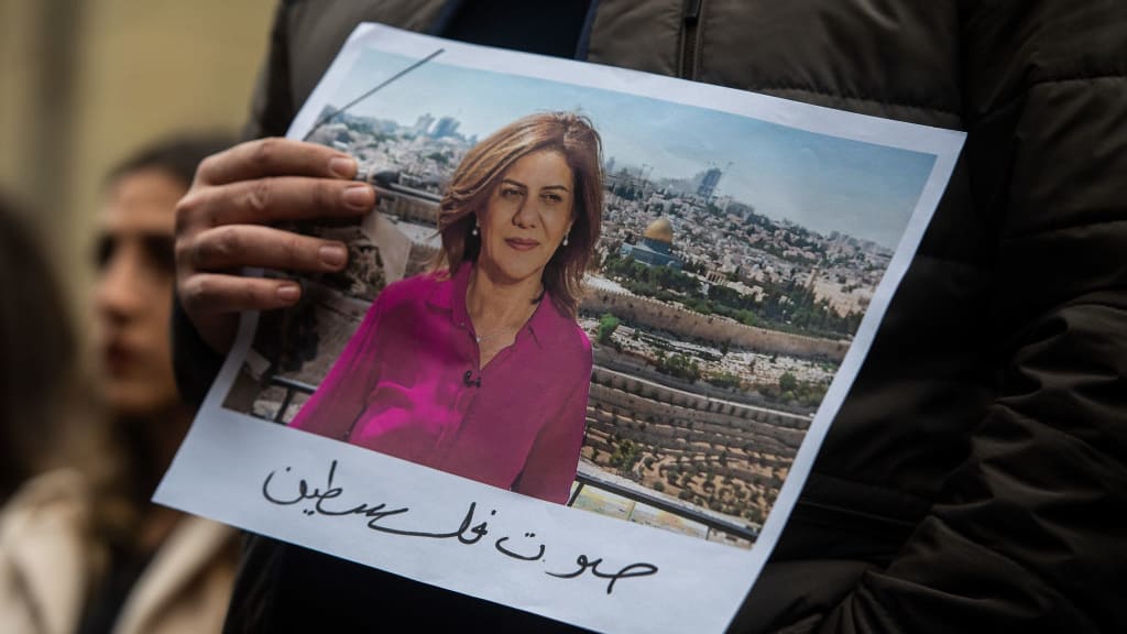 A person holds a photo of Shireen Abu Akleh during a vigil in London.