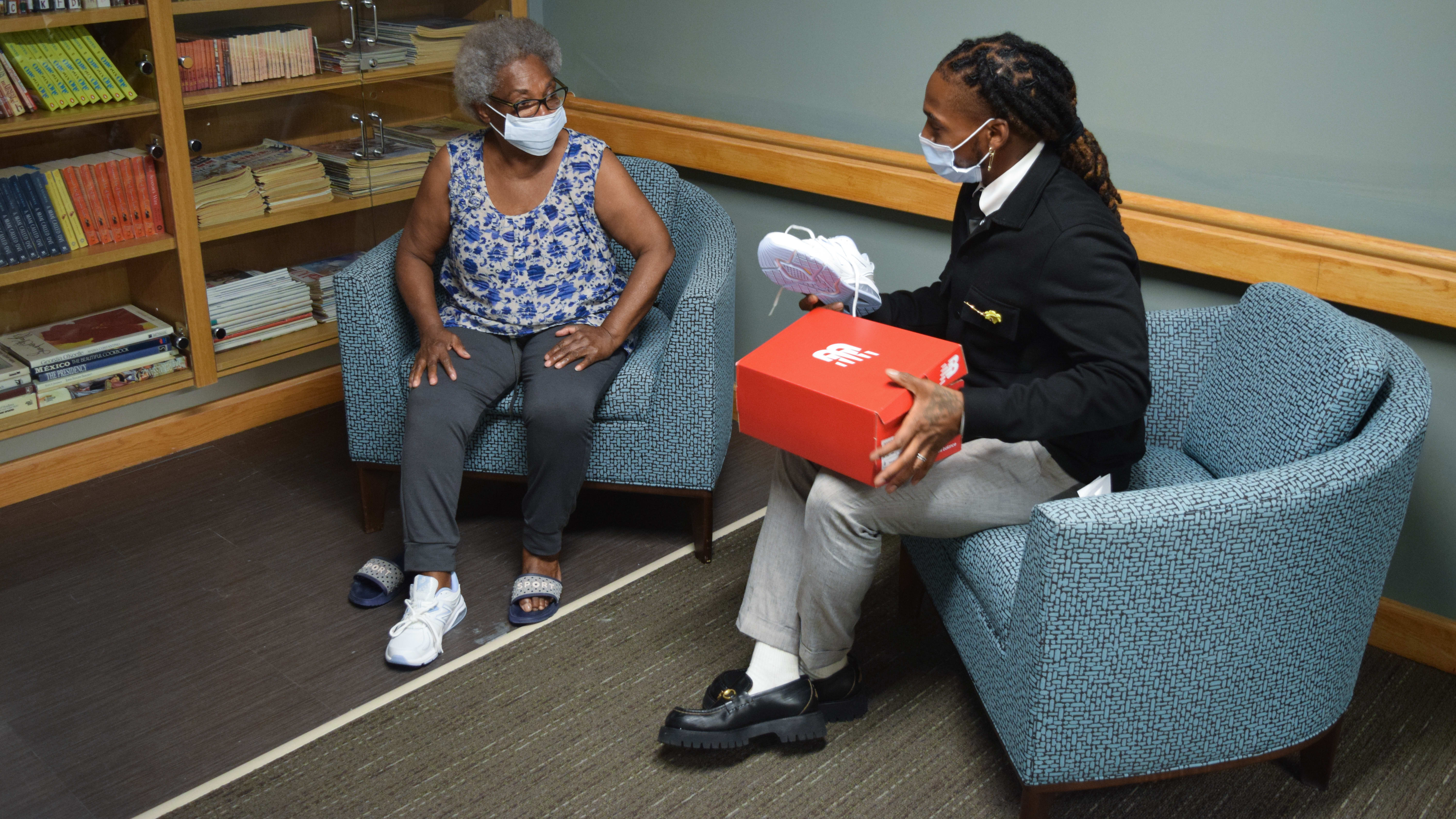 James Humphries surprises a 2Life resident with new shoes.