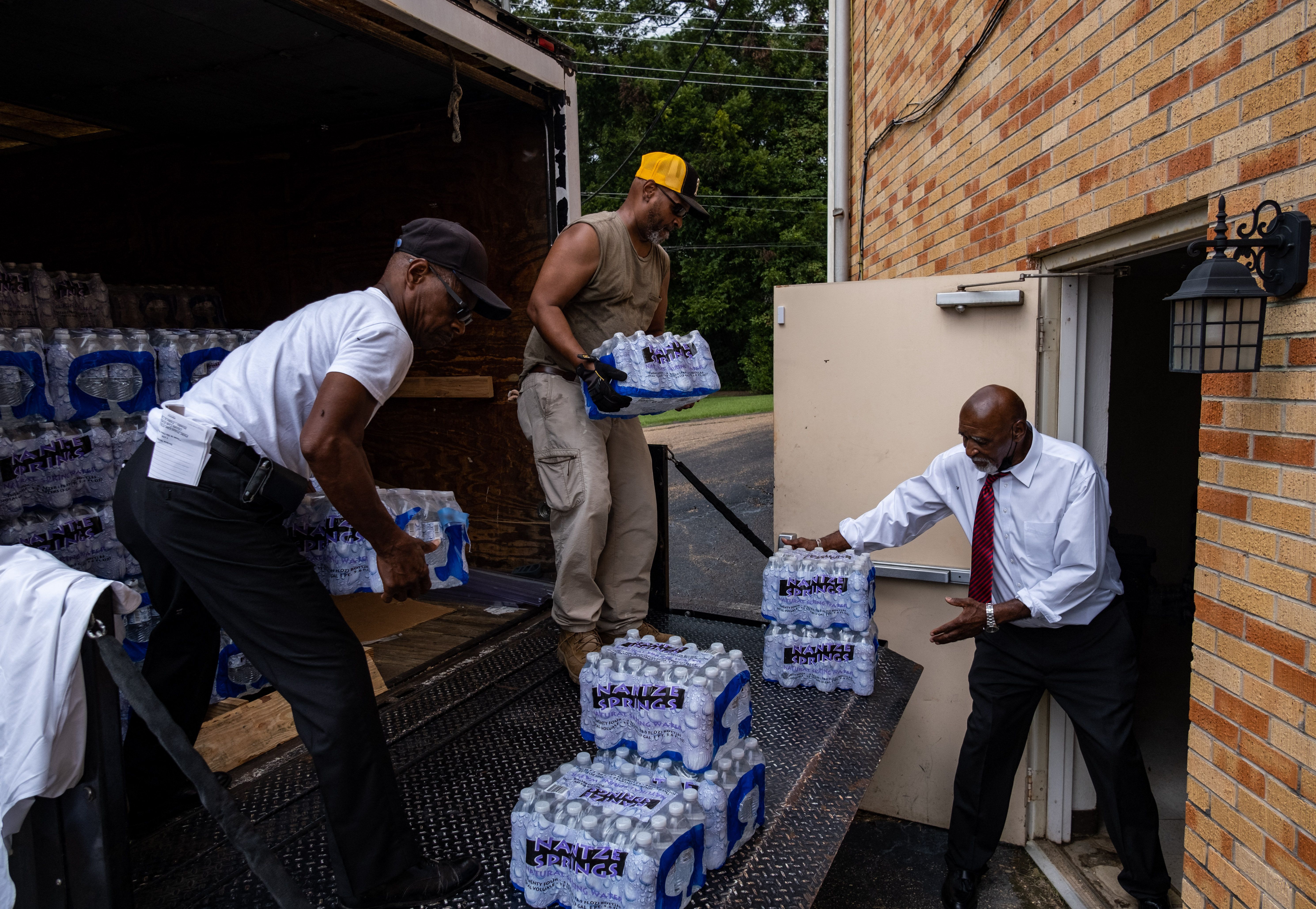 Cases of water arrive at the Progressive Morningstar Baptist Church for distribution