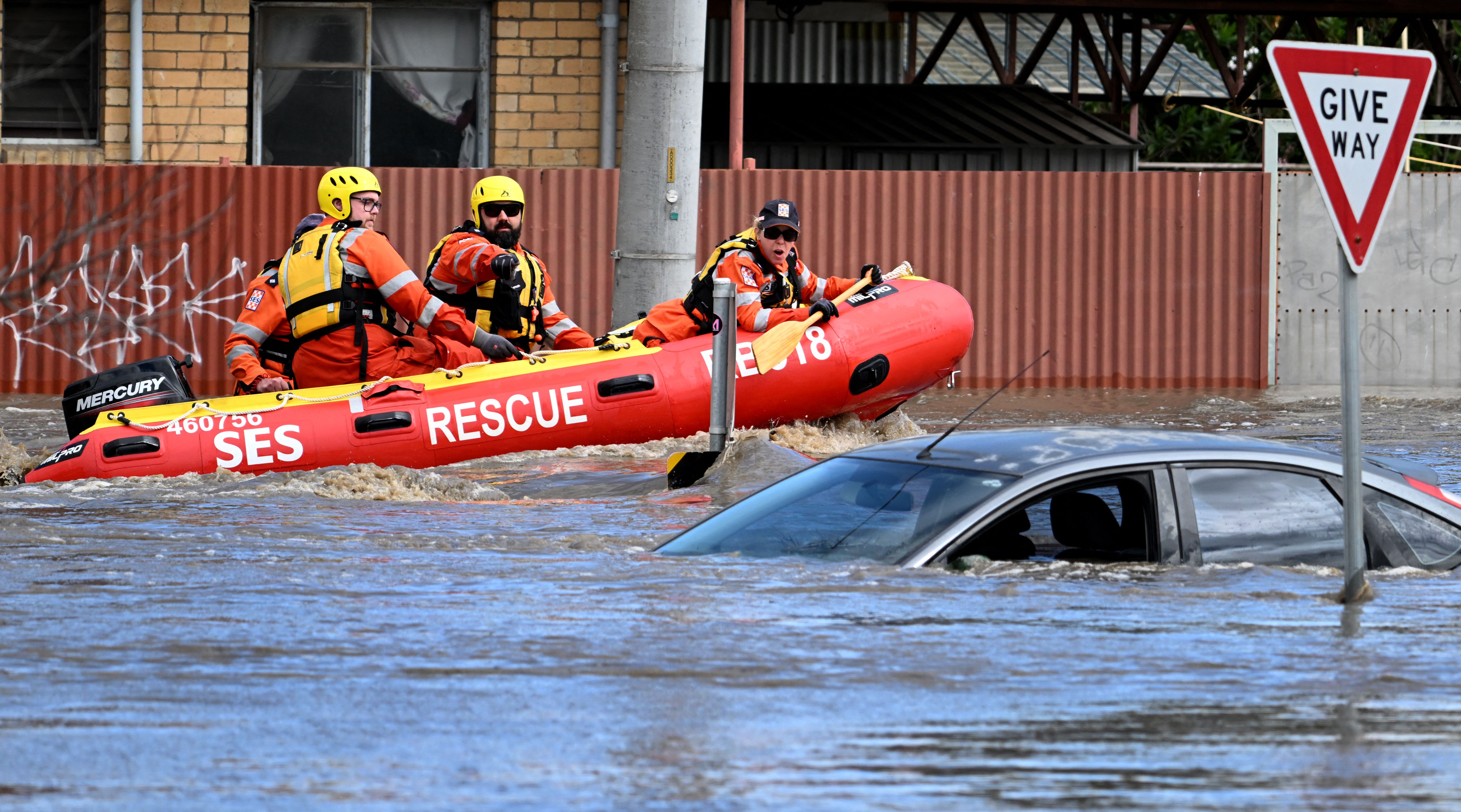 Rescue workers float down a flooded street in a Melbourne suburb. 