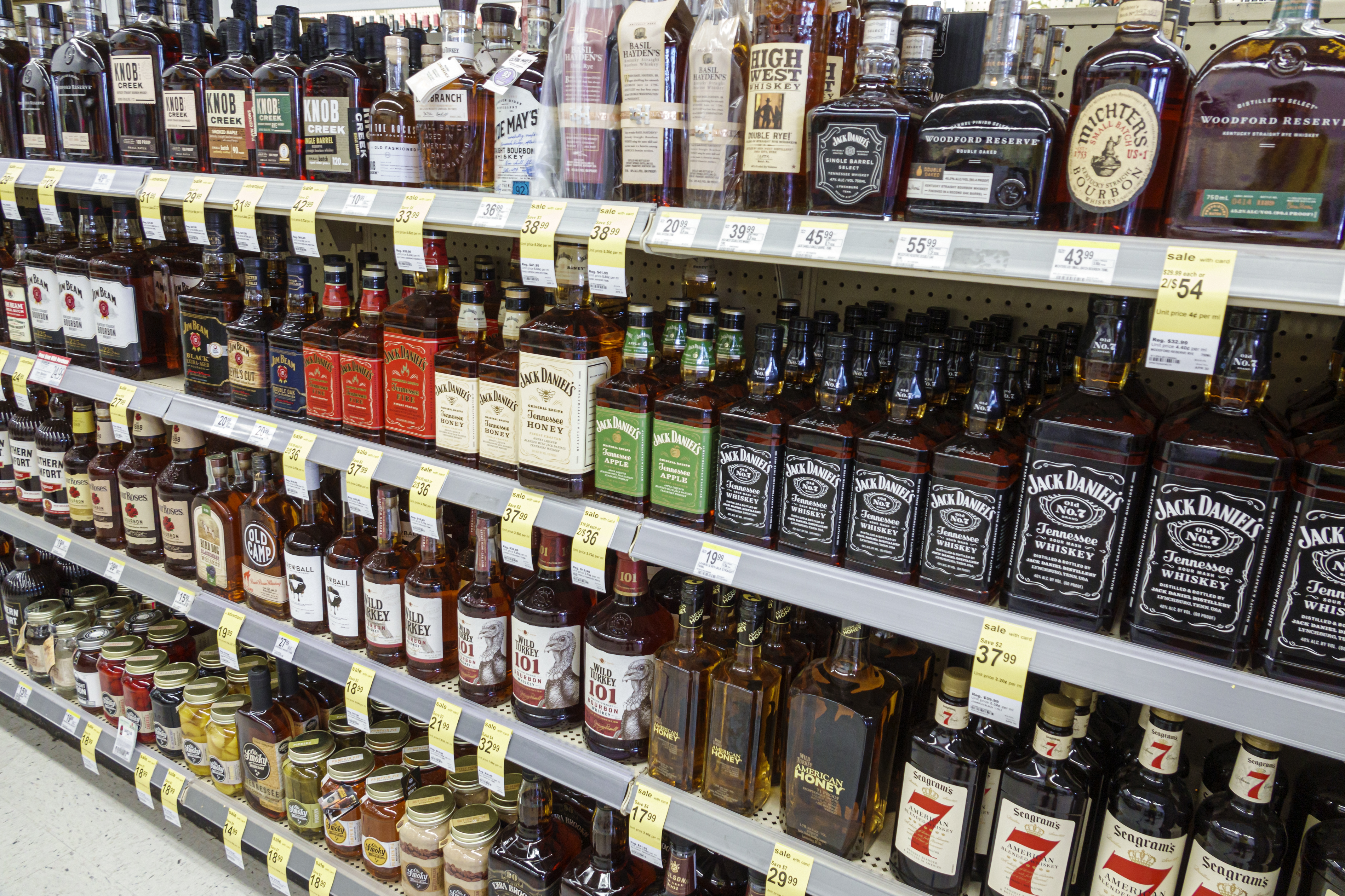 A fully stocked shelf in a liquor store. 