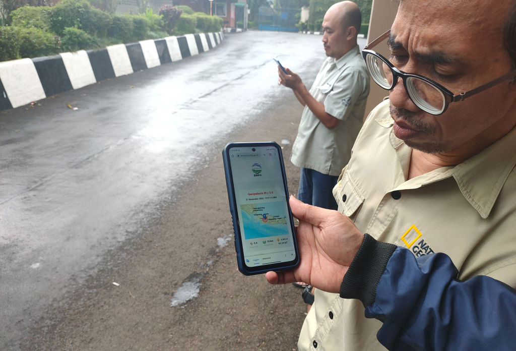 Hotel employees in Cianjur, Indonesia, check hurricane news