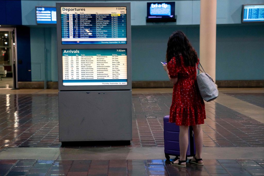 Passenger looks at Amtrak schedule in terminal.