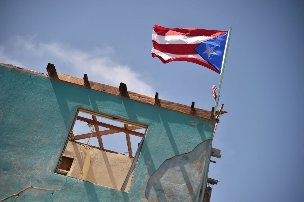 Puerto Rican flag flies on edge of building.