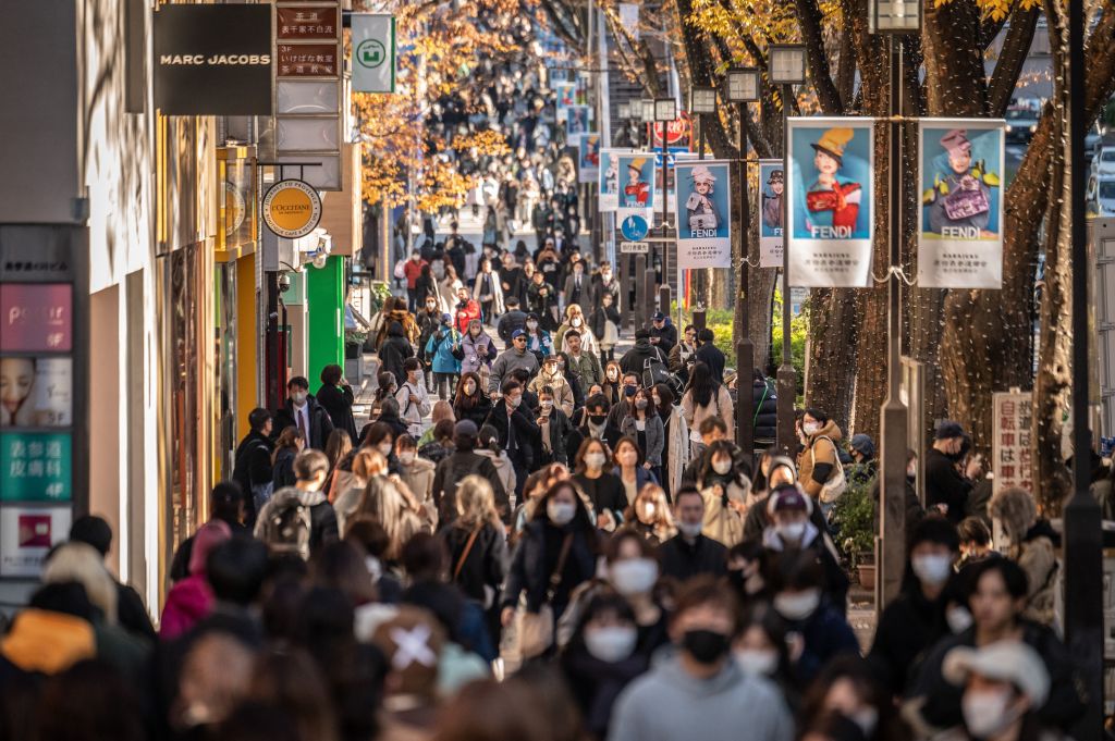 People walk through a shopping street in Omotesando area of Tokyo