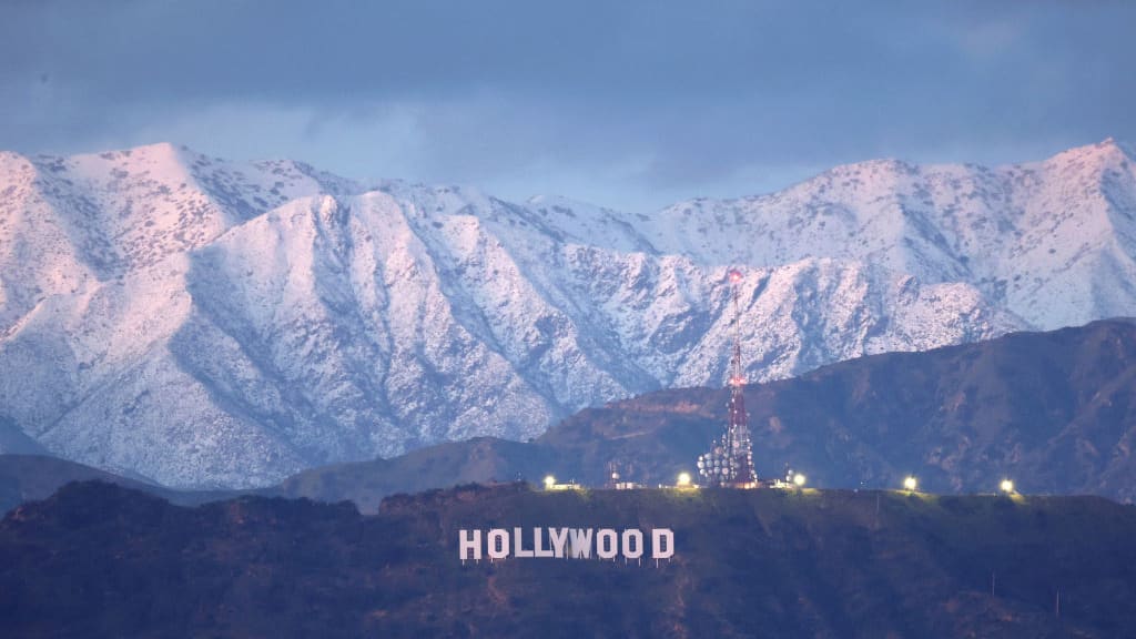 Snow in the mountains behind the Hollywood sign.