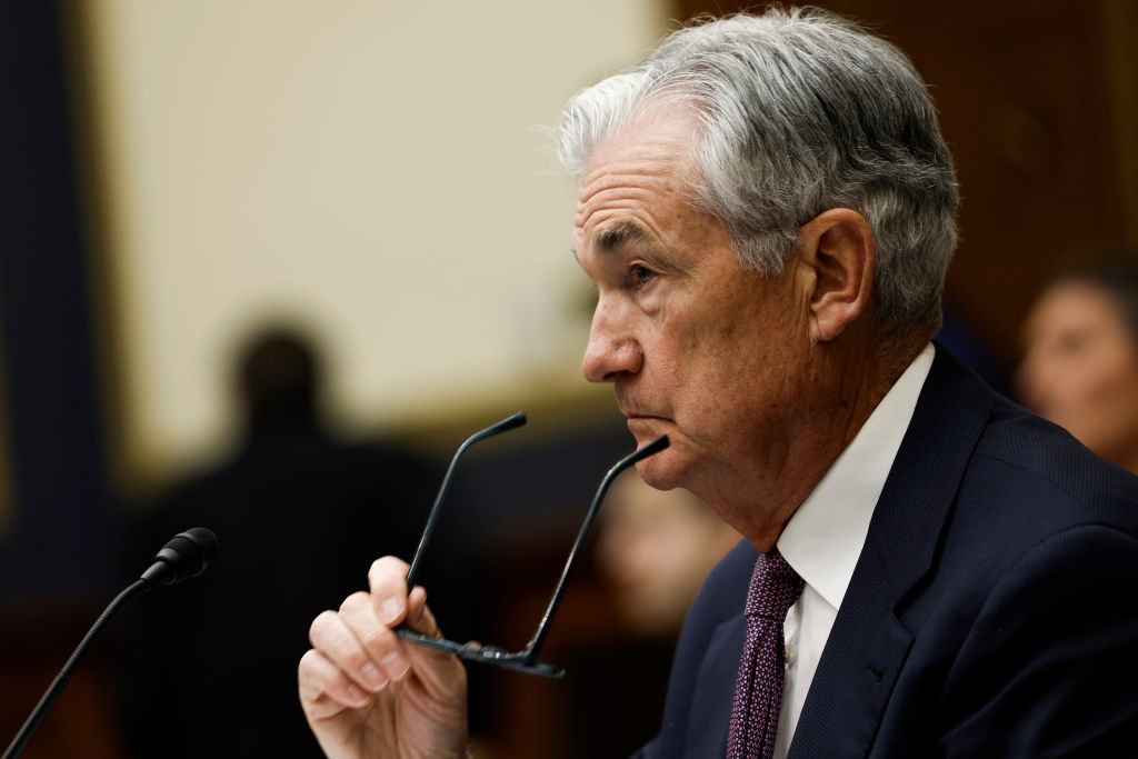 Jerome Powell removes his glasses and rests them against his chin