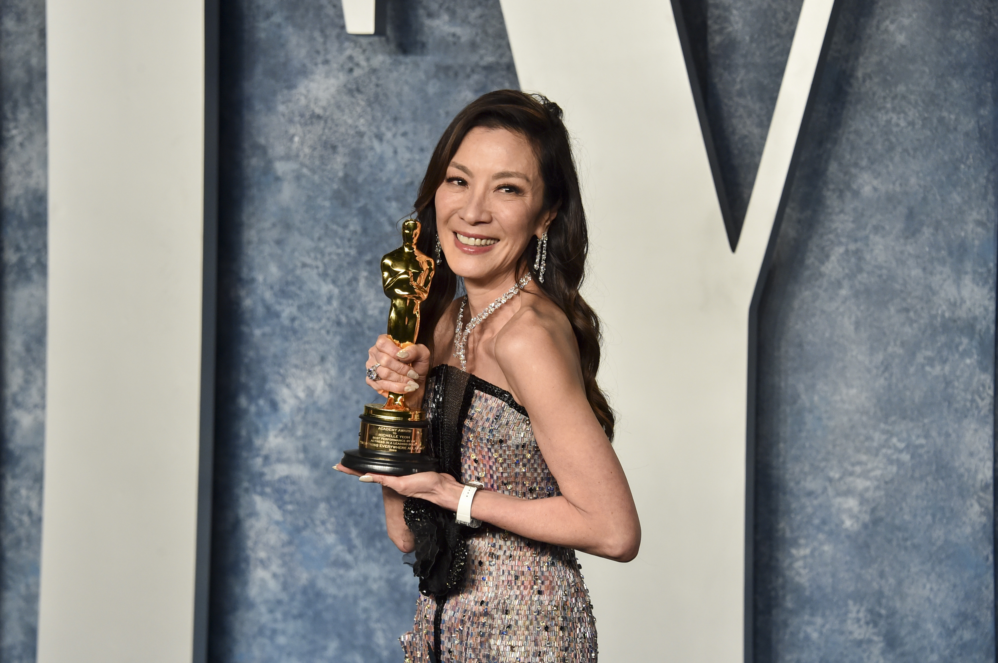 Michelle Yeoh holds up her Oscar at the 2023 Vanity Fair Oscar Party