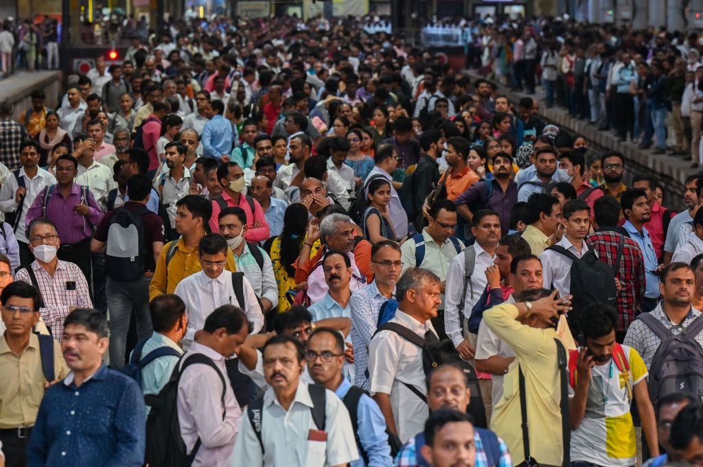 Throngs of people wait on a train platform in India. 