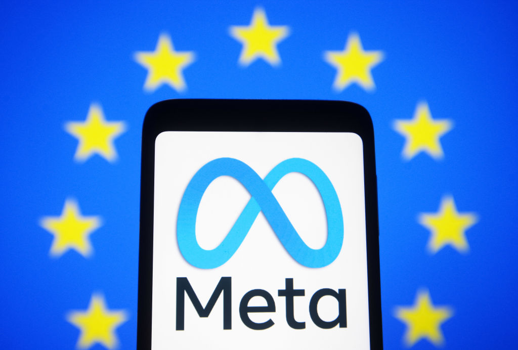 Meta logo on a smartphone screen and the European Union flag