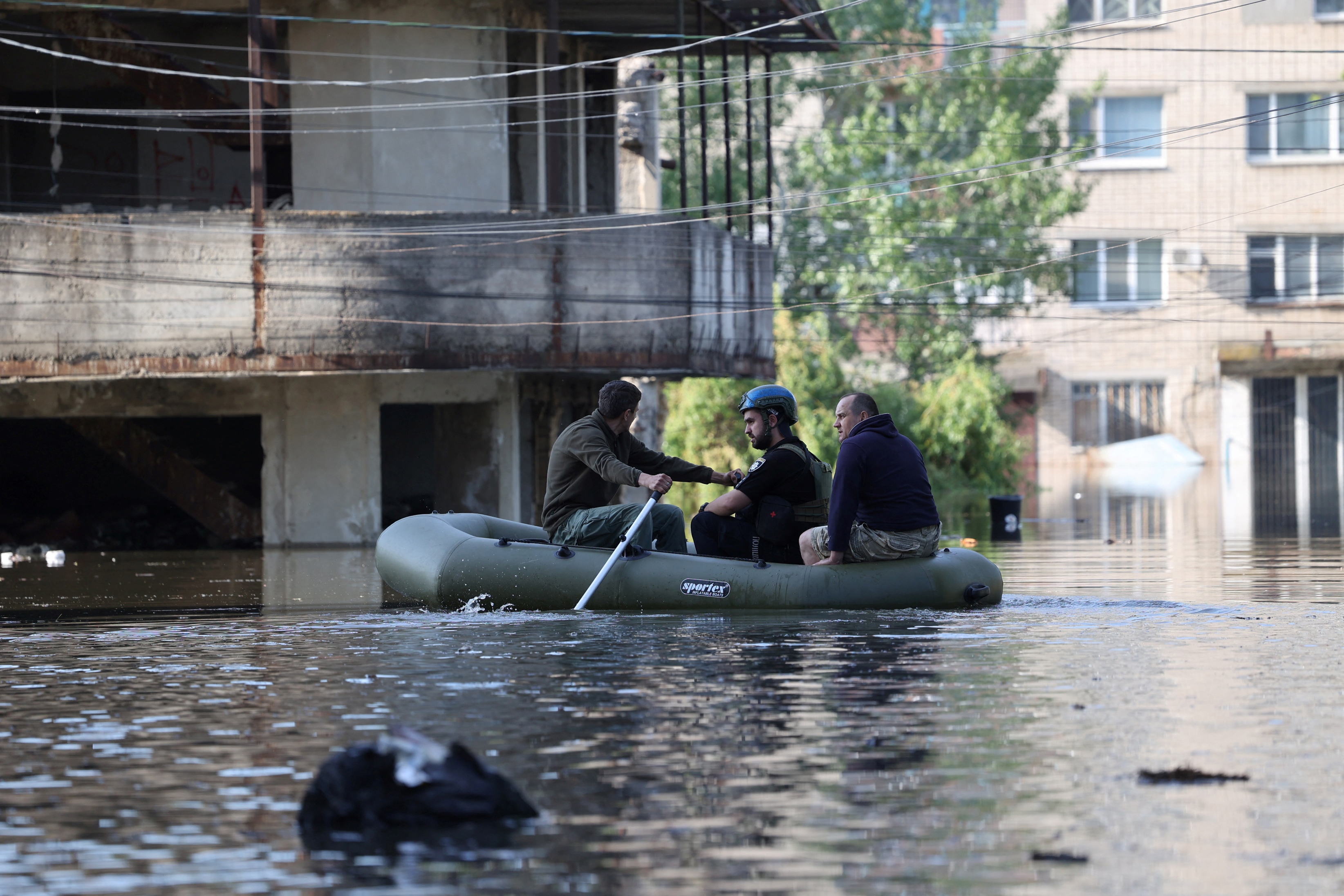 A rescue boat carrying several people out of flooded areas in Ukraine