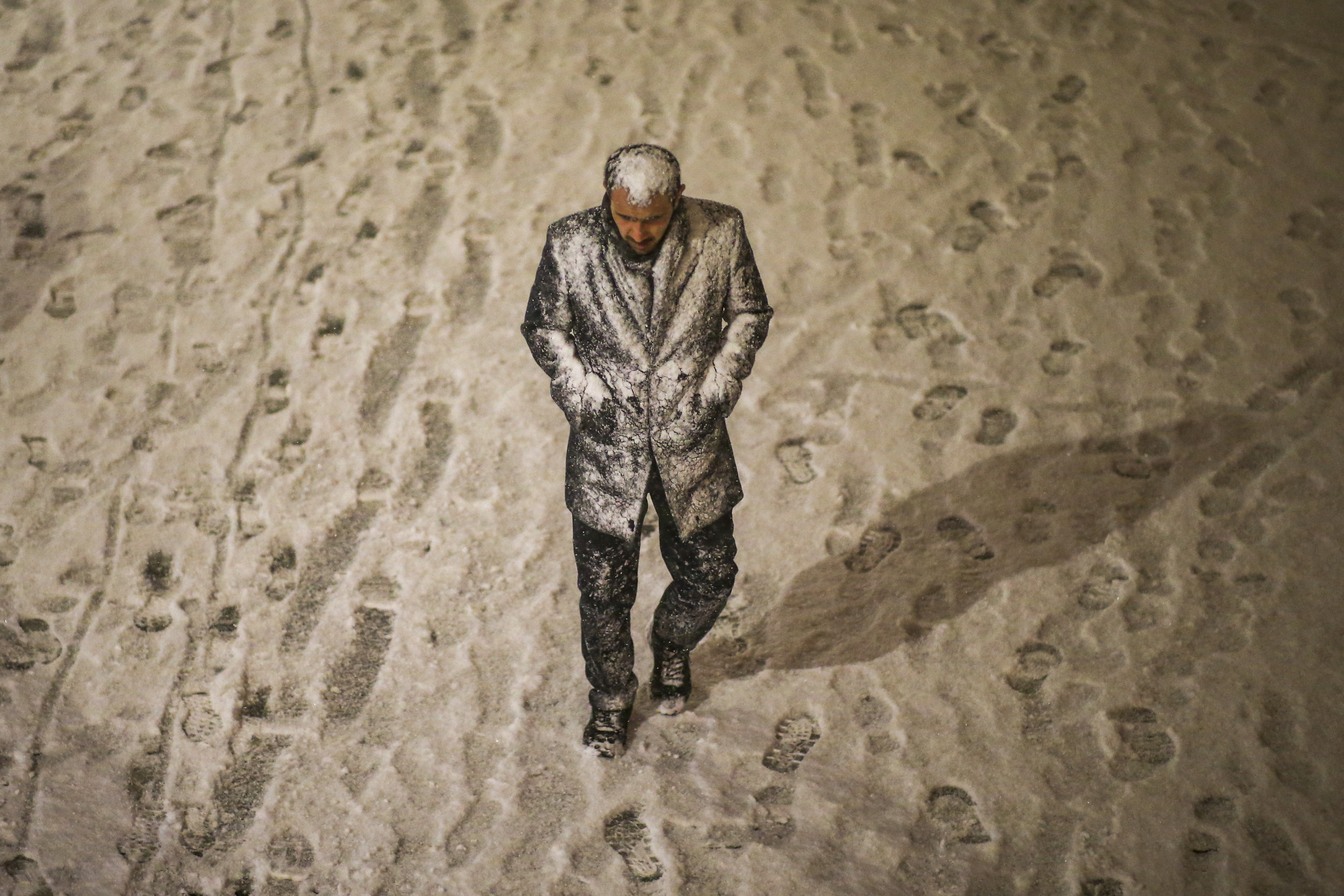 A man walking through snowfall.