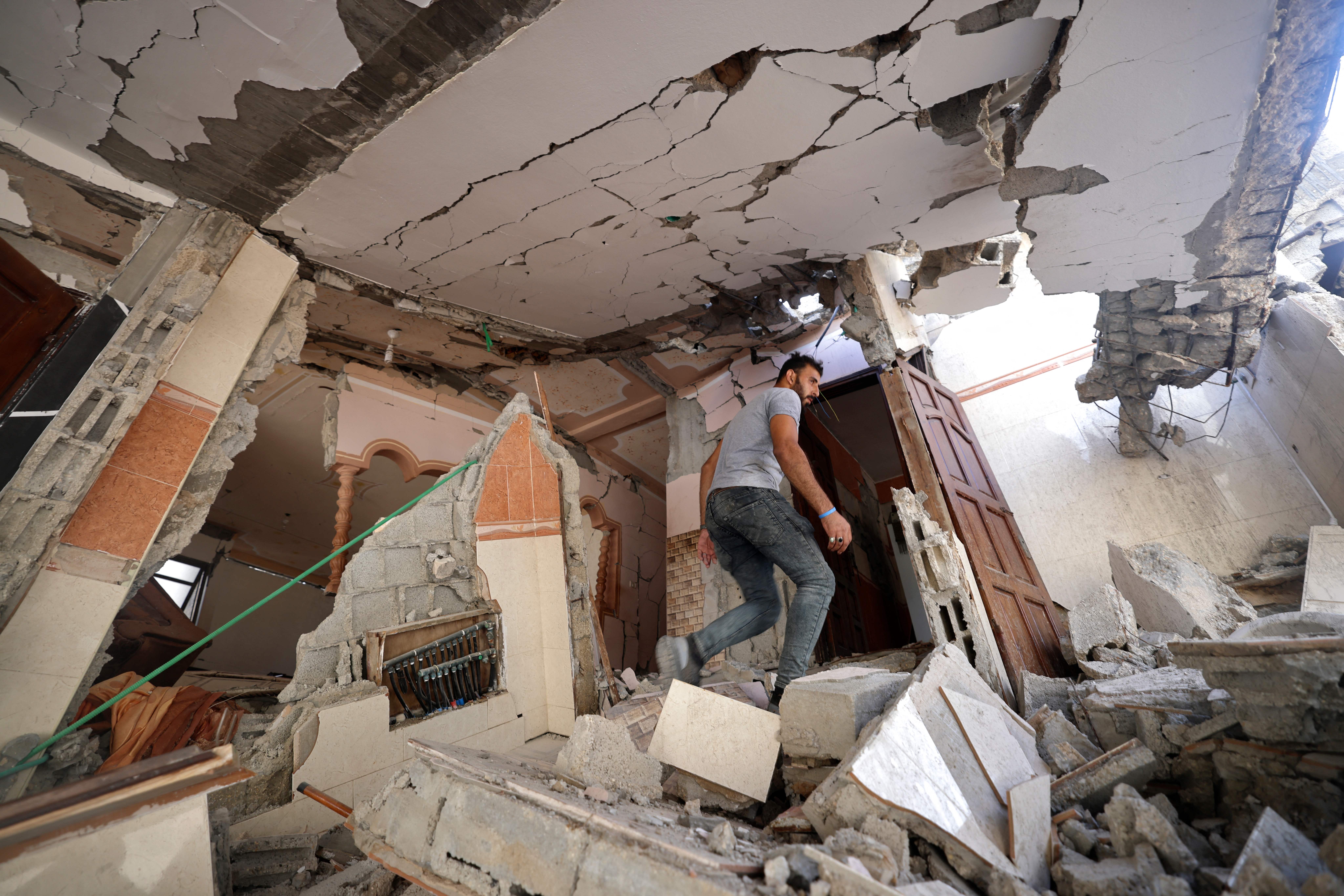 A man walks amidst the rubble of his home.