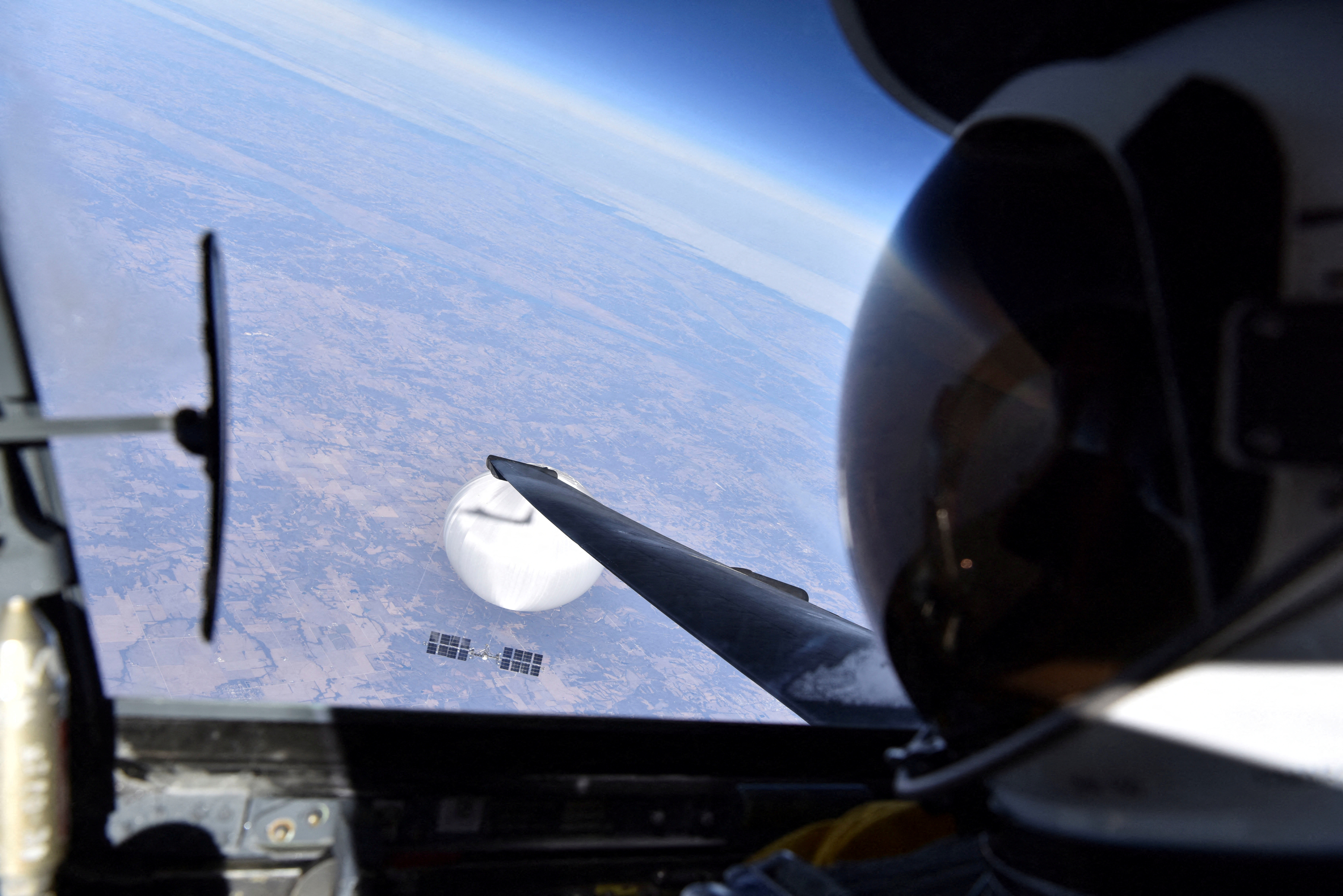 Pilot, mid-air, looks down onto spy balloon.