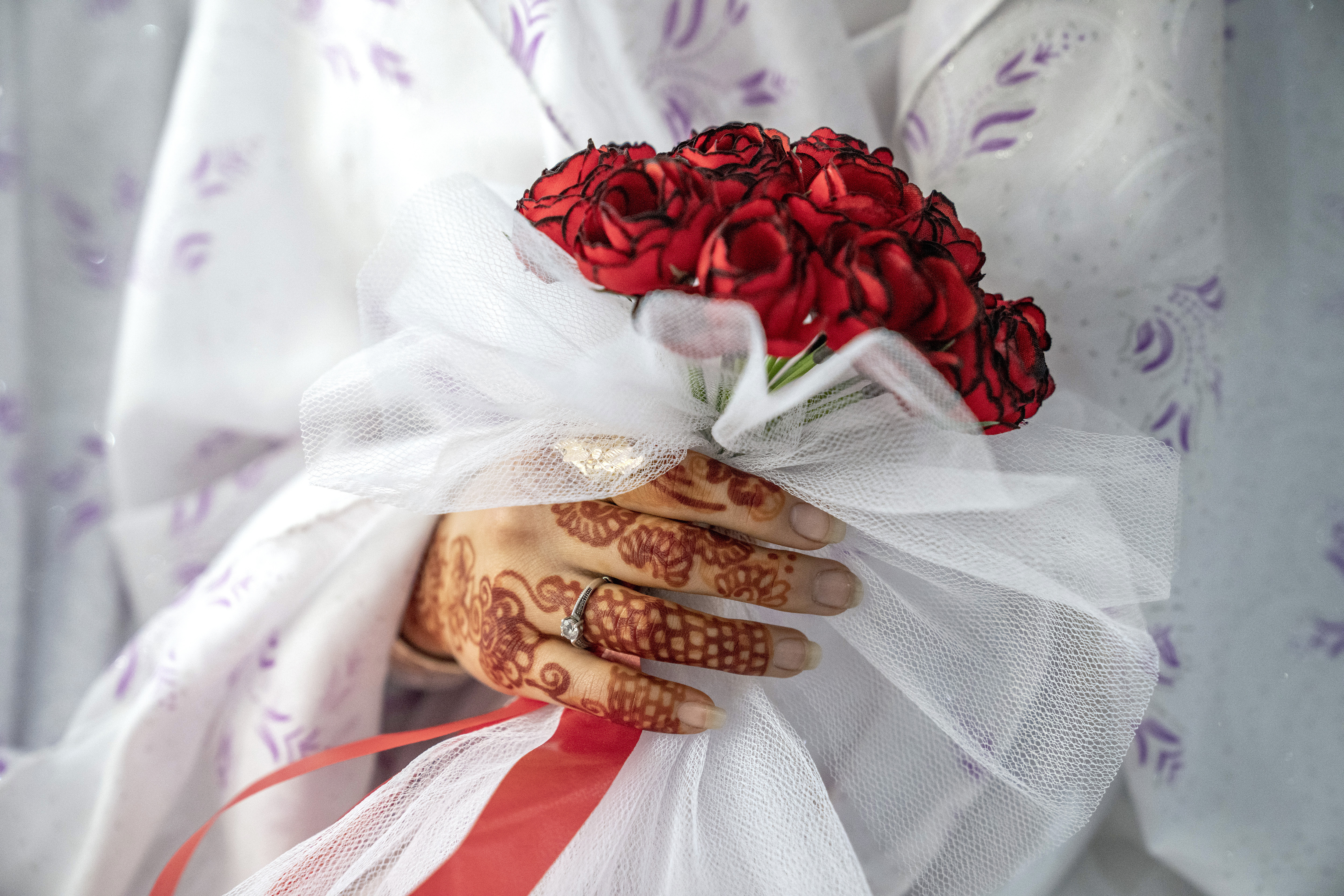 Afghan bride holds roses.