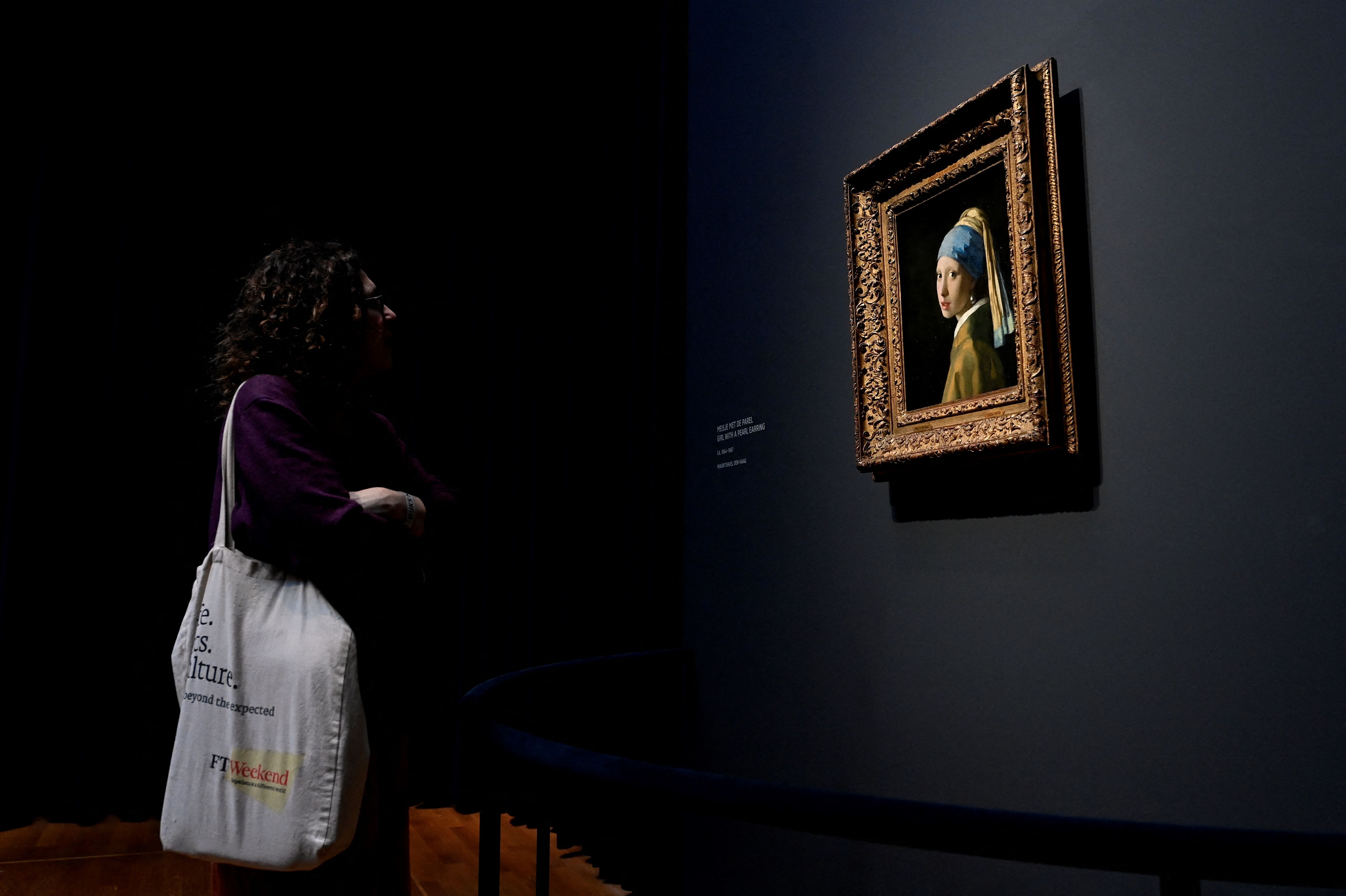 A woman looks at the Vermeer painting &quot;The Girl with a Pearl Earring&quot;