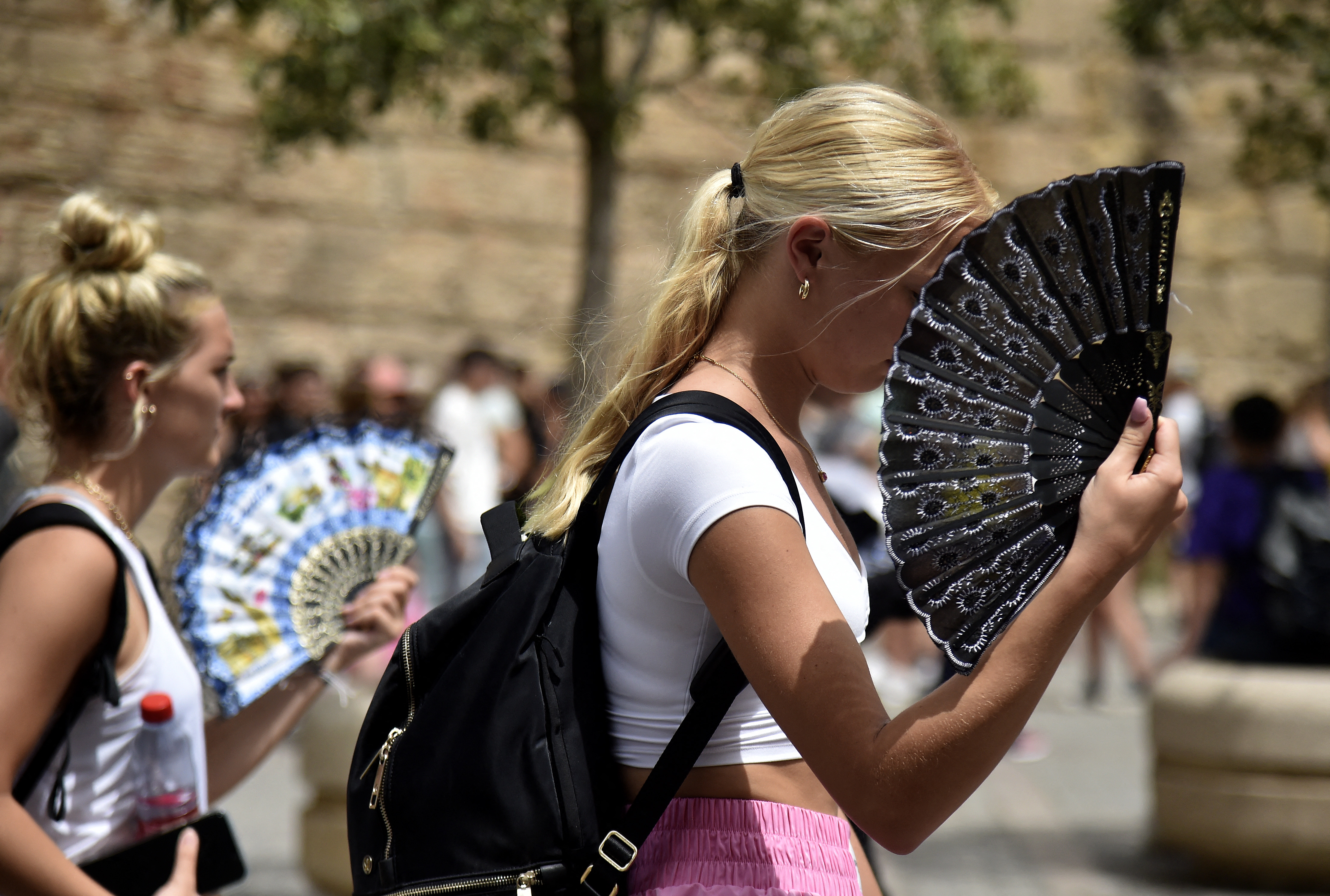 A girl uses a fan to cool herself off in Spain